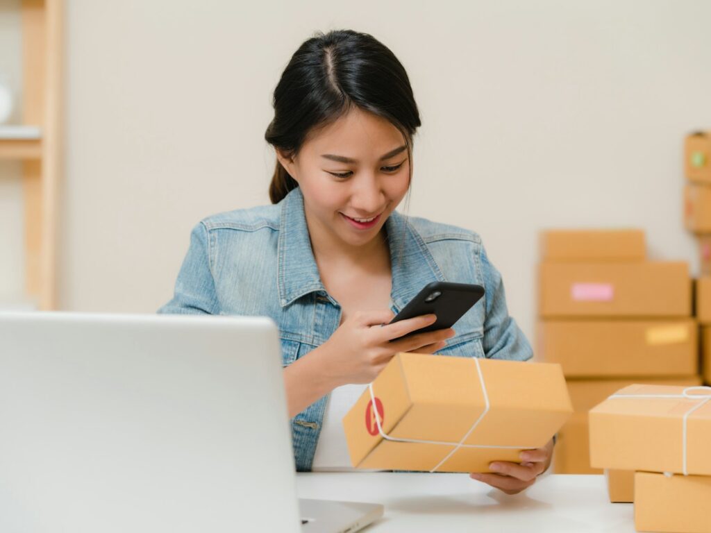 Small business owner checking a package order on her phone