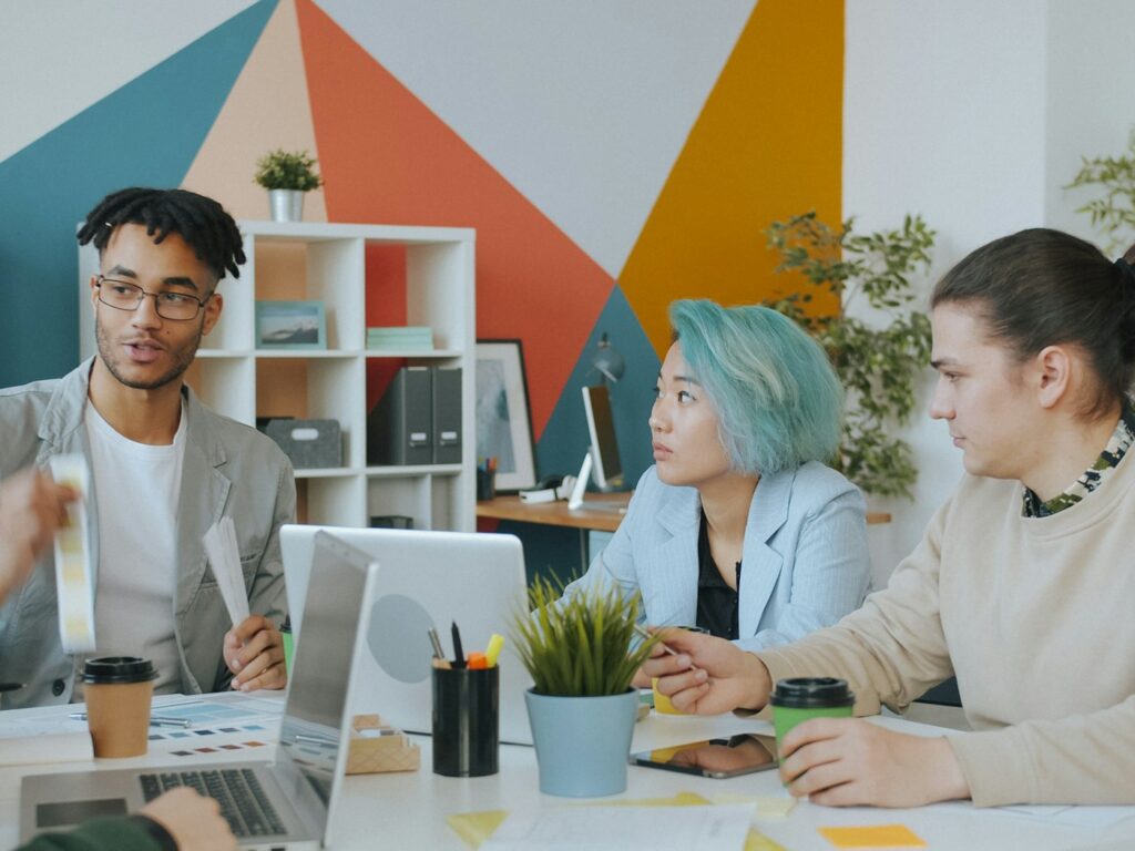 A group of four people collaborating in a colorful office