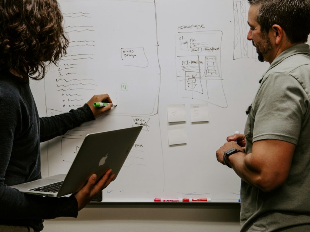 Two people planning a strategy at a whiteboard